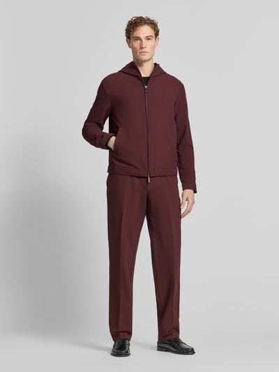Männermodel trägt Jacke mit Kapuze und Zweiwege-Reißverschluss von Emporio Armani, bordeaux, Regular-Fit, Material-Mix mit Stretch-Anteil, Eingrifftaschen, Ganzkörperansicht von vorne. Rückenlänge 66 cm, Schulterbreite 56 cm, Brustweite 58 cm, Ärmellänge 68 cm, Größe 50.