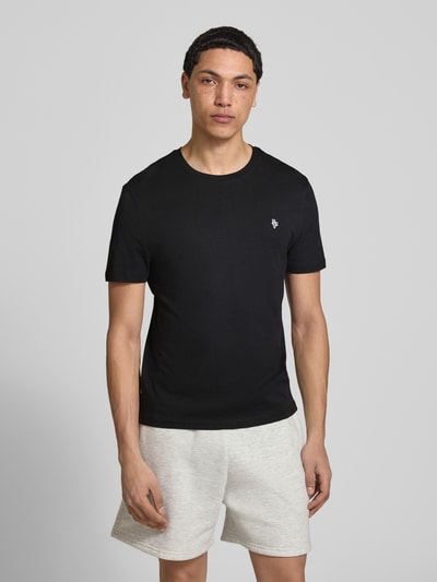 Männermodel trägt Basic Slim Fit T-Shirt mit Flock-Logo auf der Brust von REVIEW in Schwarz, Baumwoll-Viskose-Mix, Slim-Fit, Rundhalsausschnitt, Rückenlänge 64 cm bei Größe M, Ganzkörperansicht von vorne.
