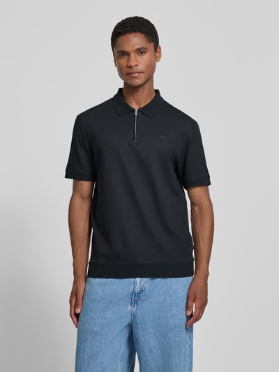 Männermodel trägt Regular Fit Poloshirt mit Strukturmuster Modell 'Tibaris' von JOOP! COLLECTION, Label-Stitching, Polokragen, Reißverschluss, Rückenlänge bei Größe M: 70 cm, dunkle Farbe, feine Textur, Ganzkörperansicht von vorne.