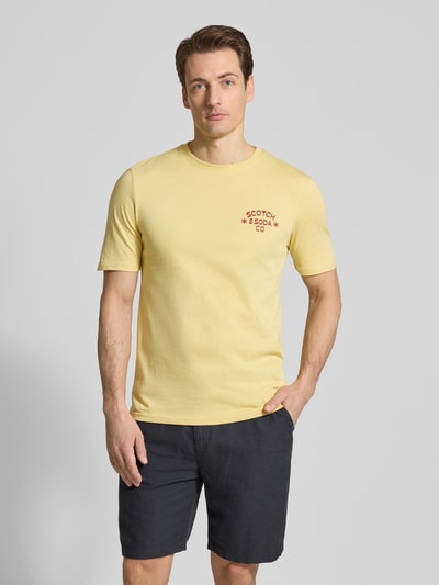 Męski model nosi T-shirt mit Rundhalsausschnitt von Scotch & Soda, bawełna, krój regular fit, nadruk z logo, długość tyłu 68 cm, Ganzkörperansicht von vorne.