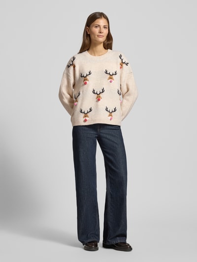 Frauenmodel trägt Weihnachtspullover in Strick-Optik Modell 'MARCIPEL' von Vila, Elastischer-Material-Mix, gerade Passform, Ganzkörperansicht von vorne.