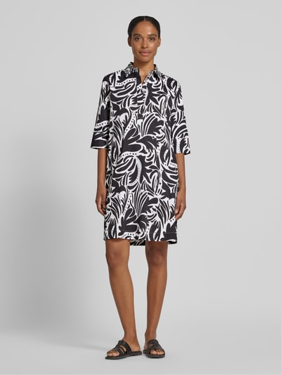 Frauenmodel trägt Knielanges Hemdblusenkleid mit verdeckter Knopfleiste von Christian Berg Woman aus Reine Baumwolle, Straight Fit, Schwarz-Weiß-Muster, Hemdblusenkragen, 1/2-Arm, Knielänge, Ganzkörperansicht von vorne.