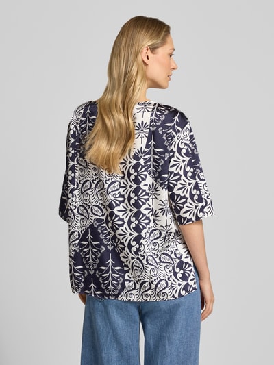 Frauenmodel trägt Blusenshirt mit 3/4-Arm Modell 'ABANO' von EMME, gerader Schnitt, florale Muster in Blau-Weiß, Ganzkörperansicht Rückansicht.