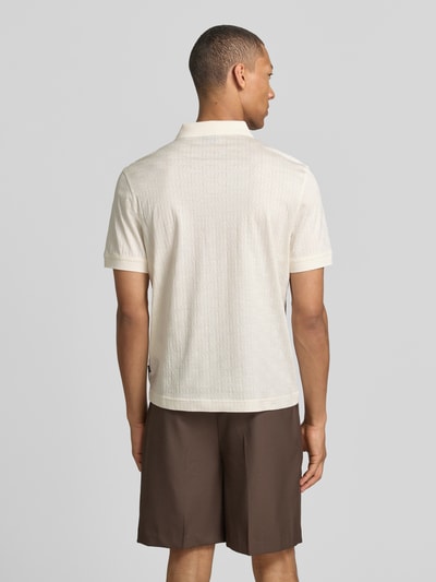 Männermodel trägt Modern Fit Poloshirt mit Strukturmuster Modell 'Roberto' von JOOP! Collection aus reiner Baumwolle, Rückenlänge 68 cm, Ganzkörperansicht Rückansicht.