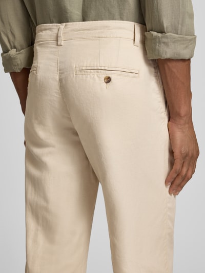 Mężczyzna nosi Regular Fit Leinenhose aus Baumwoll-Leinen-Mix Modell 'MILES' von SELECTED HOMME, unikalny kolor, krój regular fit, średni stan, 5 kieszeni, bawełna z lnem; zdjęcie z tyłu, ujęcie od pasa w dół.
