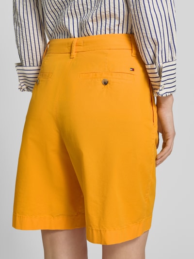 Vrouwenmodel draagt Regular Fit Chino-Shorts uit katoen-lyocell-mix van Tommy Hilfiger, look: effen, gestikt logo, achterzakken, mix van katoen en lyocell, detailopname rugaanzicht.