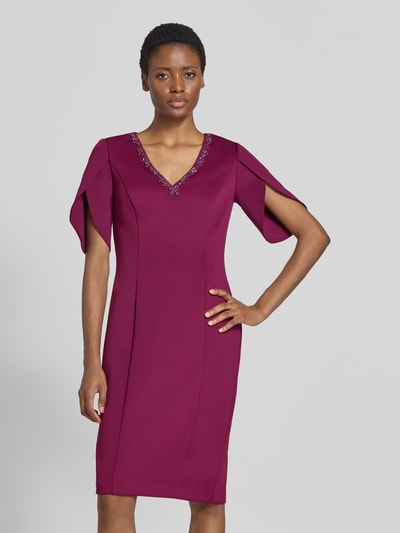 Frauenmodel trägt Knielanges Kleid mit Ziersteinbesatz von Adrianna Papell in dunklem Pink, V-Ausschnitt, taillierte Passform, Halbarm, Ganzkörperansicht von vorne. Rückenlänge 102 cm, Brustweite 37 cm, Ärmellänge 32 cm.