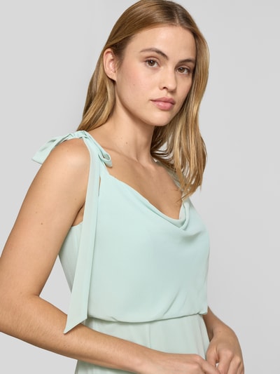 Frauenmodel trägt Knielanges Cocktailkleid mit Zierschleifen von Jake*s Cocktail in zartem Pastell, Ärmelloses-Design, tailliert, Nahaufnahme Oberkörper. Rückenlänge in Größe 36 beträgt 97 cm, Brustweite 33 cm, blickdichter Unterrock, angenehme Textur.