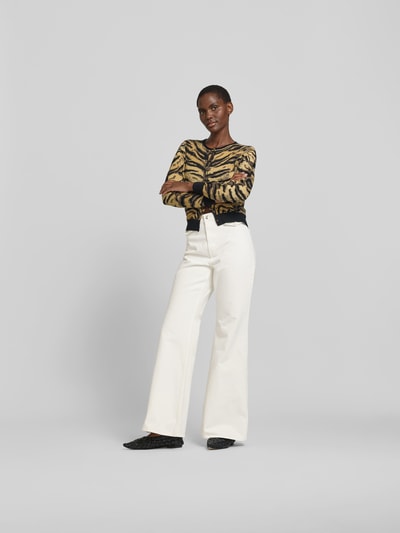 Frauenmodel trägt Flared Fit Jeans mit Pattentaschen von ROTATE aus reiner Baumwolle, weiß, sichtbare Knopf- und Reißverschluss, Ganzkörperansicht von vorne.