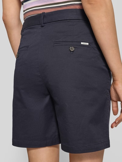Frauenmodel trägt Bermudas mit Gesäßleistentaschen von Gant, dunkelblauer Baumwoll-Mix, Straight Fit, Produktdetails sichtbar, Ganzkörperansicht Rückansicht.
