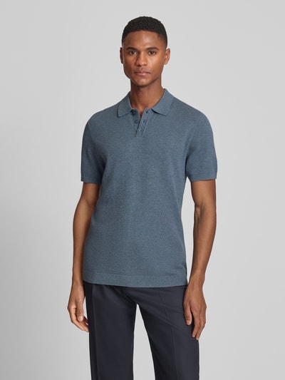 Mężczyznamodel nosi koszulkę polo Slim Fit Poloshirt Modell 'Triton' od Drykorn z bawełny, kołnierzykiem polo, fakturowany wzór, krótki rękaw, widok całej sylwetki z przodu.