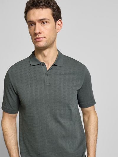 Männermodel trägt Regular Fit Poloshirt aus reiner Baumwolle von Marc O'Polo, Optik: Unifarben, Gitterkaro Struktur, Nahaufnahme Oberkörper.