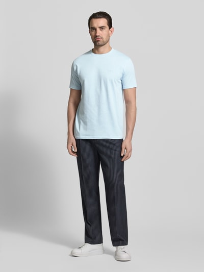 Männermodel trägt T-Shirt mit Rundhalsausschnitt und Label-Stitching von Gant aus reiner Baumwolle im Regular-Fit, hellblau, Ganzkörperansicht von vorne.