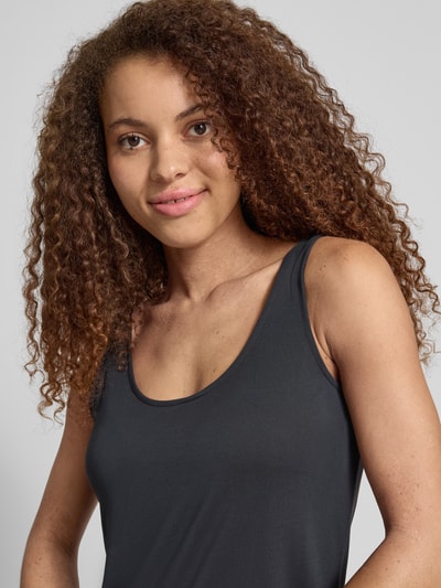 Vrouwenmodel draagt Relaxed fit tanktop uit modal-mix model 'KAMALA' van Pieces, uni zwart, smalle bandjes, U-hals, half close-up bovenlichaam.