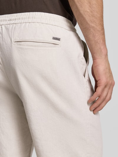 Männermodel trägt Bermudas mit französischen Eingrifftaschen Modell 'COLI' von Fynch-Hatton, Baumwoll-Mix mit Leinen-Anteil, Loose-Fit, Gesäßleistentaschen, farblich dezentes Design, Struktur aus leichtem Stoff, Nahaufnahme Rückansicht.