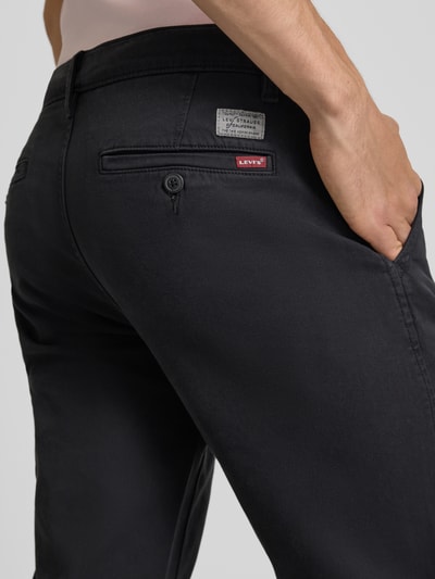 Mężczyznamodel nosi Regular Fit Chino aus Baumwoll-Mix Modell 'CHINO II' od Levi's®, czarne, gładka tekstura, detal tylnej części, Nahaufnahme pośladków.