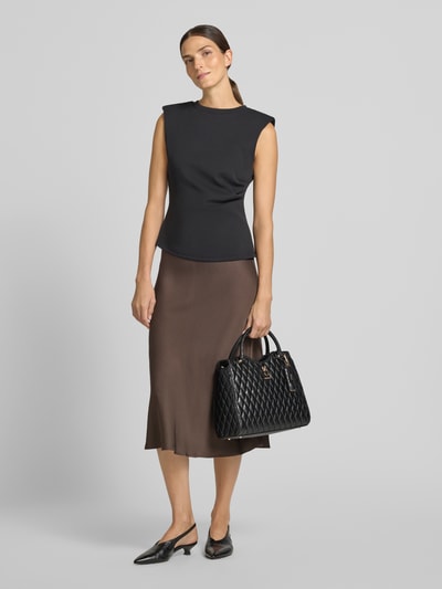 Frauenmodel trägt Tote Bag in Stepp-Optik Modell 'Latona' von GUESS, schwarz, abnehmbarer Schulterriemen, Ganzkörperansicht von vorne. Damen Tote Bag, Hauptfach mit Reißverschluss, Maße 33x28x12 cm, Riemen 122 cm.