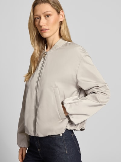 Kobiece modelka nosi Regular Fit Blouson mit Baseball-Kragen von Marc O'Polo, efekt: jednolity kolor, krój regular fit, kształt kołnierza: baseball-kragen, zamek błyskawiczny, długi rękaw, bufiaste rękawy, wykończenie: elastyczny tunel, wpuszczane kieszenie, materiał z recyklingu. Ujęcie: całe ciało z przodu.
