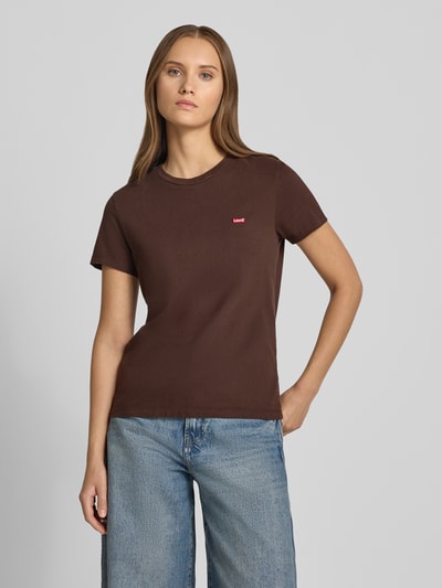 Frauenmodel trägt Loose Fit T-Shirt aus reiner Baumwolle von Levi's® in Braun, glatte Textur, kombiniert mit blauer Jeans, Ganzkörperansicht von vorne.