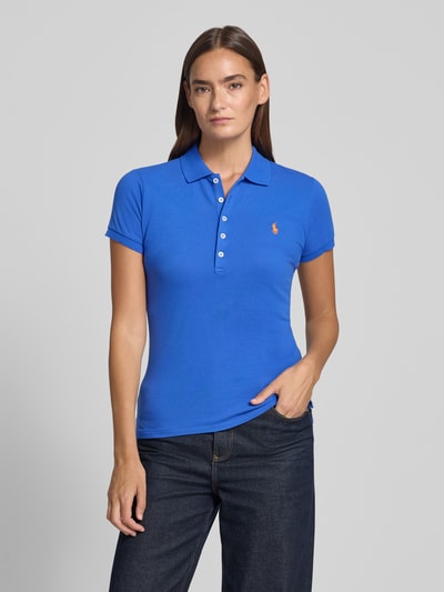Vrouwenmodel draagt Regular Fit poloshirt uit katoenmix model 'JULIE' van Polo Ralph Lauren, look: effen, logostitching, korte mouw, piqué materiaalverwerking, blauwe kleur, zijsplitten, vooraanzicht bovenlichaam.