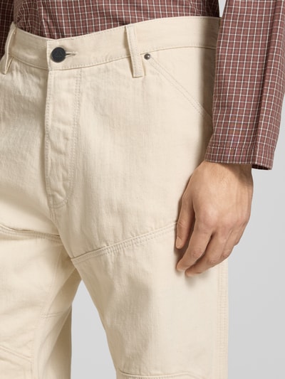 Mężczyzna nosi Wide Fit Jeans mit Gesäßtaschen von G-Star Raw z bawełny, wpuszczane kieszenie, zapięcie na guzik i zamek błyskawiczny, szerokość w rozmiarze 32/32: 45 cm, długość wewnętrzna nogawki: 81 cm, jasny kremowy kolor, faktura gładka, detal kieszeni, zbliżenie na górną część nogawki.