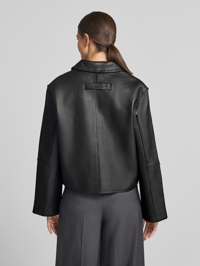 Frauenmodel trägt Relaxed Fit Jacke in Leder-Optik Modell 'SALYLO' von Samsøe Samsøe in Schwarz, strukturierte Oberfläche, Ganzkörperansicht Rückansicht. Damen Jacke mit Umlegekragen und Zweiwege-Reißverschluss.