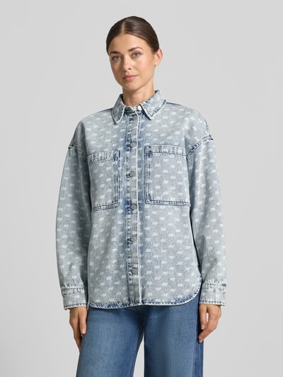 Kobiece model prezentuje Oversized Jeansbluse mit Alpaka-Anteil od Armani Exchange, elastyczna mieszanka materiałów, kołnierzyk koszulowy, listwa guzikowa na całej długości, nakładane kieszenie na piersi, szerokie ramiona, nadruk z logo na całej powierzchni, długość tyłu w rozmiarze S: 45 cm, widok całej sylwetki z przodu.