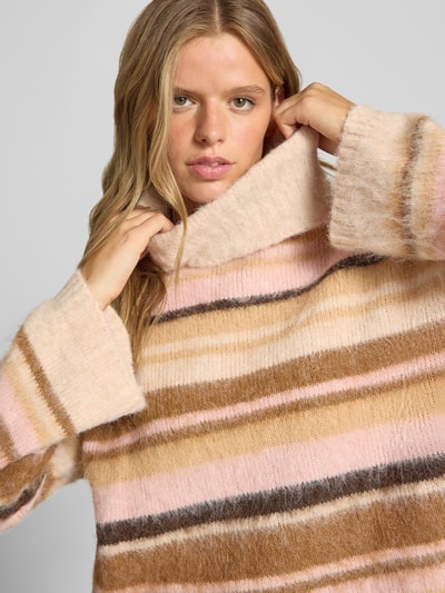 Kobiece modelka nosi Loose Fit Rollkragenpullover mit Woll-Anteil Modell 'PERIL' od ONLY, pastelowe paski, miękka faktura, zbliżenie na górę ciała. Pulower damski.