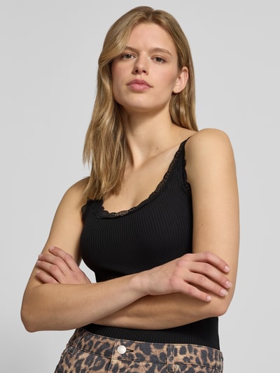 Frauenmodel trägt Slim Fit Tanktop aus reiner Baumwolle Modell 'DIMARTINI_B' von Hugo Blue, unifarben, Logo Print, Nahaufnahme Oberkörper.