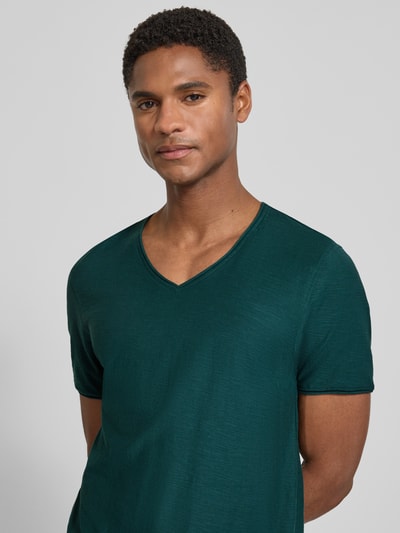 Männermodel trägt T-Shirt mit V-Ausschnitt und Rollsaum von MCNEAL in Smaragdgrün, Reine Baumwolle, Regular-Fit, Nahaufnahme Oberkörper.
