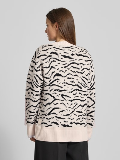 Frauenmodel trägt Strickjacke mit Knopfleiste von Marc Cain aus reiner Baumwolle, lockerem Schnitt, gerippte Abschlüsse, Rückenlänge 68 cm, Ganzkörperansicht Rückansicht.