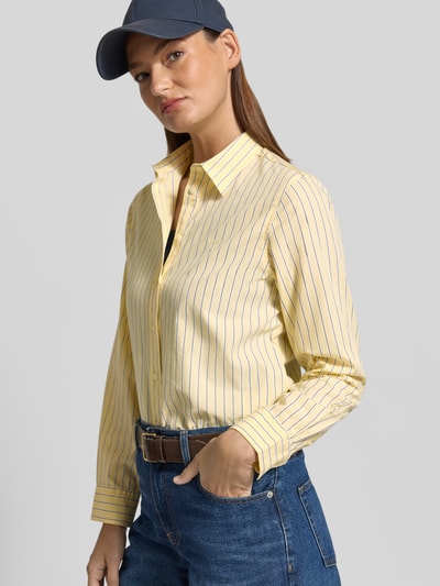 Frauenmodel trägt Regular Fit Bluse mit Label-Stitching Modell 'ONEBUY' von Gant, gelb mit blauen Streifen, reine Baumwolle, Knopfleiste, Hemdblusenkragen, Nahaufnahme Oberkörper.