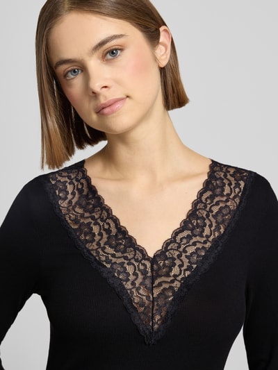 Vrouwenmodel draagt Shirt met lange mouwen met kant, effen design, V-hals, viscosemix van PIECES Model 'SIRI', nauwsluitend model, Nahaufnahme Oberkörper.