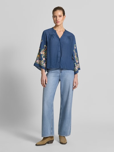 Frauenmodel trägt Regular Fit Bluse aus Viskose-Mix mit Stitchings von Apricot, dunkelblau mit bunten Details, V-Ausschnitt, Ganzkörperansicht von vorne.