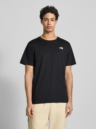 Männermodel trägt Regular Fit T-Shirt aus Baumwoll-Mix Modell 'EVOLUTION' von The North Face, schwarz mit Label-Detail, Ganzkörperansicht von vorne. Herren T-Shirt mit Rundhalsausschnitt, Rückenlänge bei Größe M 71 cm.