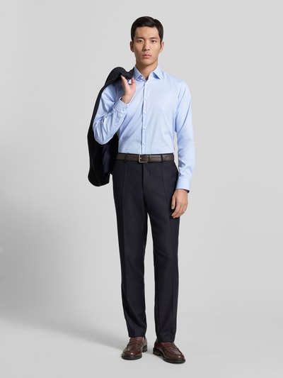 Männermodel trägt Regular Fit Business Hemd aus Baumwolle mit Kentkragen von Jake*s in Hellblau, Ganzkörperansicht von vorne. Rückenlänge 70 cm, Schulterbreite 47 cm, Ärmellänge 64 cm, Knopfleiste, glatte Textur.