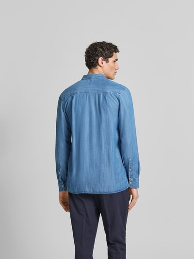 Männermodel trägt Relaxed Fit Jeanshemd aus reinem Lyocell von Officine Générale in hellem Blau, weiche Textur, Langärmelig, Rückenansicht Ganzkörperansicht, durchgehende Knopfleiste, Brusttasche, Rückenlänge 76 cm, Schulterbreite 45 cm, Ärmellänge 66 cm, Größe M.