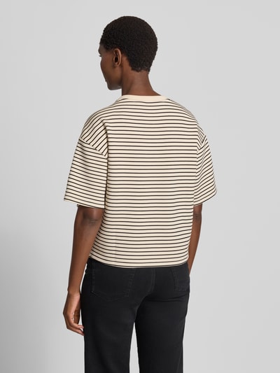 Männermodel trägt Oversized Fit T-Shirt aus Viskose-Mit von MSCH Copenhagen, beżowe z czarnymi paskami, mieszanka wiskozy, okrągły dekolt, krój oversized fit, rękaw o dł. 1/2, długość tyłu w rozmiarze XS/S: 54 cm, widok całej sylwetki z tyłu.