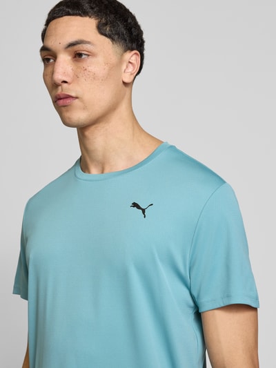 Männermodel trägt TRAINING T-Shirt mit Label-Detail Modell von PUMA PERFORMANCE, Herren T-Shirt in Blau, Rundhalsausschnitt, Kurzärmelig, Gerader-Schnitt, dezentes Label-Detail, glatte Textur, Rückenlänge bei Größe M: 73 cm, Nahaufnahme Oberkörper