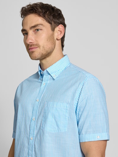 Männermodel trägt Regular Fit Freizeithemd mit Brusttasche von Christian Berg Men, Reine Baumwolle, Button-Down-Kragen, hellblau-weiß gestreift, Kurzärmelig, durchgehende Knopfleiste, Ganzkörperansicht von vorne.