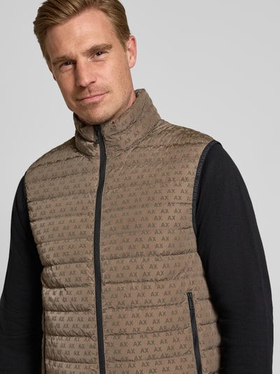 Mannelijk model draagt Regular fit bodywarmer van Armani Exchange, Model 'PIUMINO', Eendendons- en verenvulling, All-over logoprint, opstaande kraag, tweewegritssluiting, ruglengte maat M 67 cm, schouderbreedte 46 cm, borstwijdte 54 cm. Nahaufnahme Oberkörper