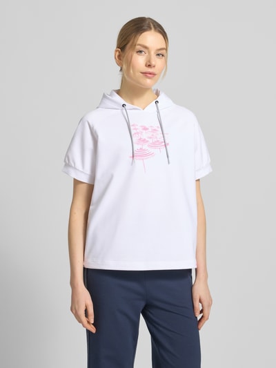 Modelka kobieca nosi białe T-Shirt aus Baumwoll-Mix mit Kapuze Modell 'SHARON3' von FIRE + ICE z różowym nadrukiem, luźny krój, krótki rękaw, widok całej sylwetki z przodu.