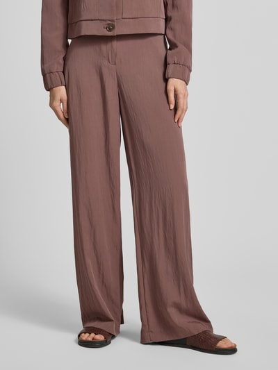 Kobiece modelka nosi Hose mit französischen Eingrifftaschen von Christian Berg Woman Selection, kolor brązowy, materiał z mieszanki wiskozy, krój loose fit, zapięcie na haczyk i zamek, francuskie kieszenie boczne, kieszenie z tyłu, szerokość w rozmiarze 36: 39 cm, długość nogawki od wewnątrz 81 cm, tekstura lekko marszczona, pełny przód, zbliżenie na dolną część ciała.
