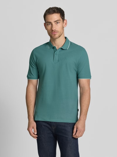 Męski model nosi Slim Fit Poloshirt mit Stitching von Jack & Jones Premium z bawełny, krój slim fit, haft, listwa guzikowa, długość tyłu w rozmiarze M: 70 cm, widok całej sylwetki z przodu.