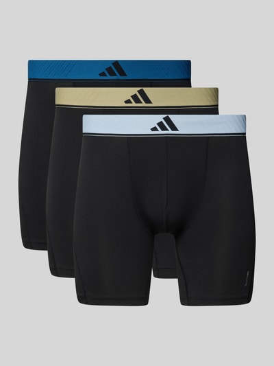 Produktfoto, Trunks im 3er-Pack mit elastischem Logo-Bund von adidas Sportswear, Optik: Unifarben, Logo-Print, Bundabschluss: Elastisch, Multipack:3er-Pack, Materialverarbeitung: Jersey, drei schwarze Herren Trunks mit unterschiedlich farbigen elastischen Logo-Bünden vor grauem Hintergrund.
