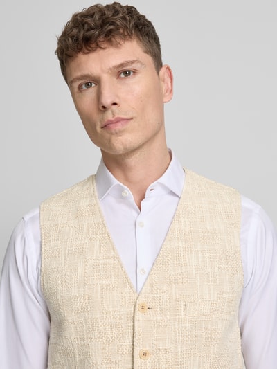 Männermodel trägt Weste mit V-Ausschnitt Modell 'Morley' von CG - Club of Gents aus beigem Baumwoll-Mix, Nahaufnahme Oberkörper, Regular-Fit, strukturierte Textur, Knopfleiste, Eingrifftaschen, elegante Herren Weste