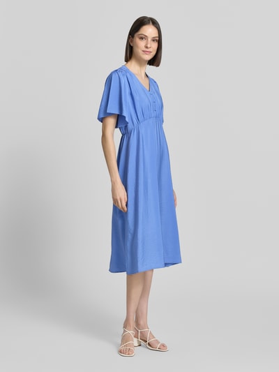 Frauenmodel trägt das Midikleid aus Viskose-Mix mit V-Ausschnitt Modell 'Aniva' von ICHI, tailliert, kurzärmelig, knielang, Ganzkörperansicht von vorne.