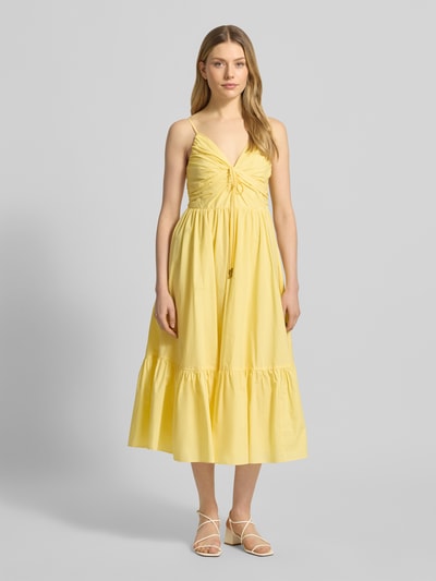 Frauenmodel trägt Midikleid mit Volantsaum und V-Ausschnitt von MICHAEL Michael Kors, Reine Baumwolle, A-Linie, Ganzkörperansicht von vorne.