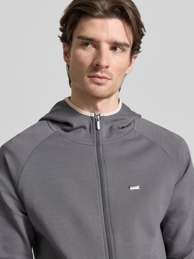 Männermodel trägt Regular Fit Sweatjacke aus Baumwoll-Mix Modell 'SENSE' von BOSS in Grau, Kapuze, Reißverschluss, Nahaufnahme Oberkörper.