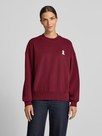 Frauenmodel trägt Oversized Sweatshirt aus reiner Baumwolle Modell 'ALIZAA' von ARMEDANGELS in Dunkelrot, dezentes Logo vorn, Ganzkörperansicht von vorne. Damen Sweatshirt von ARMEDANGELS.